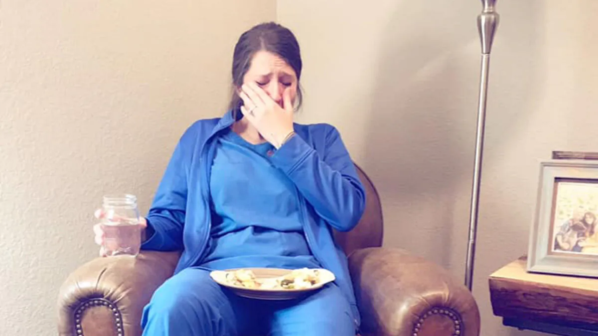 Nurse Caty Nixon slumps in a chair and sobs. (Courtesy of Laura McIntyre/Facebook)