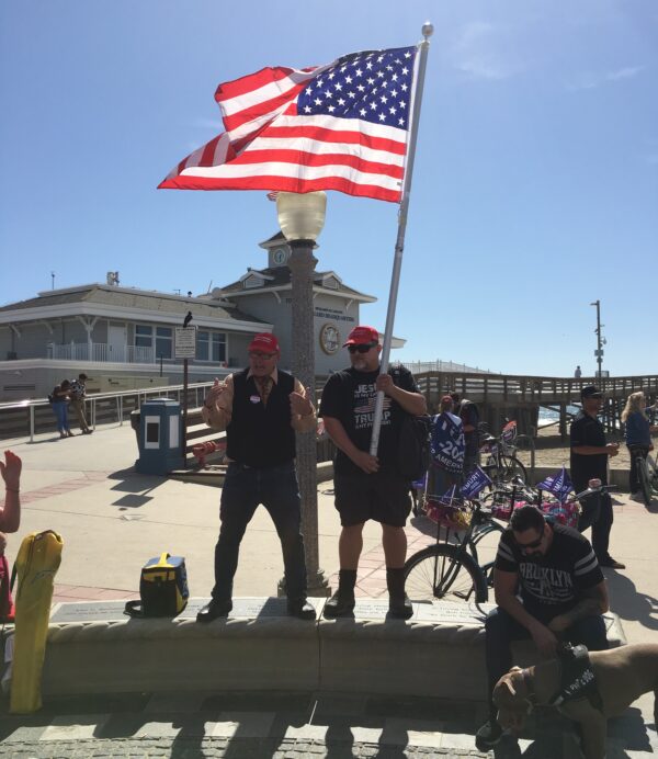 Two men hold an American flag