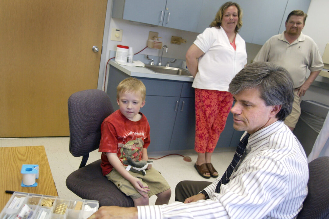 Seven-year-old sits in a chair with a doctor at the Loyola Oakbrook Medical Center in  Illinois, in a file photo. (Tim Boyle/Getty Images)