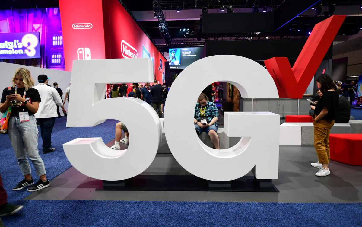 Cellphone users stand beside a Verizon 5G display at the 2019 Electronic Entertainment Expo, also known as E3, in Los Angeles, Calif., U.S. on June 12, 2019. (Frederic J. Brown/AFP/Getty Images)