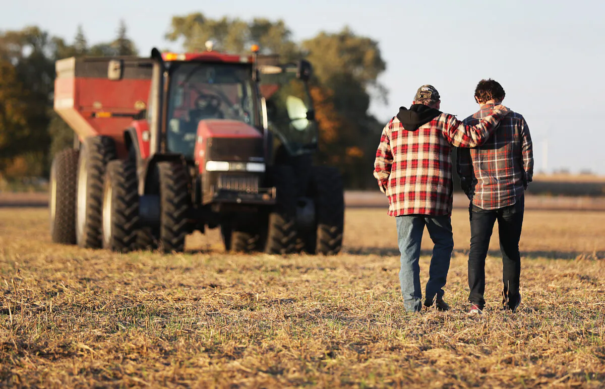 Roy Bardole walks with his grandson Gabe Bardole during the soybean harvest at the Bardole & Son's Ltd farm, in Rippey, Iowa, on Oct. 14, 2019. (Joe Raedle/Getty Images)