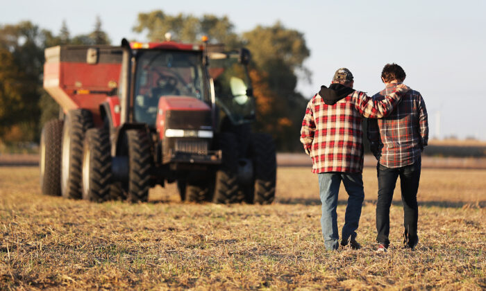 Roy Bardole walks with his grandson Gabe Bardole during the soybean harvest at the Bardole & Son's Ltd farm, in Rippey, Iowa, on Oct. 14, 2019. (Joe Raedle/Getty Images)