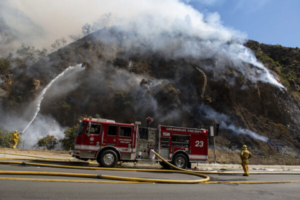 Firefighters begin hosing down the flames