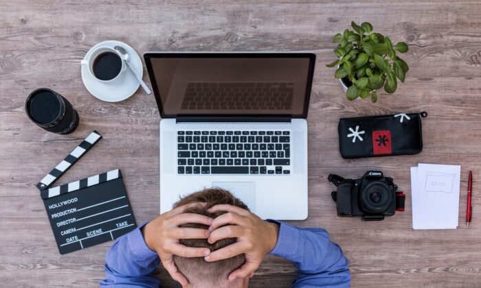 A frustrated writer stares at his computer in this file photo. Freelance writers in California are limited by a new bill to only 35 submissions per publication. (Lukas Bieri/Pixabay)
