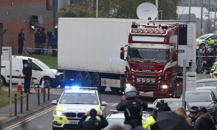 Police escort the truck, that was found to contain a large number of dead bodies, as they move it from an industrial estate in Thurrock, south England, on Oct. 23, 2019. (Alastair Grant/AP)
