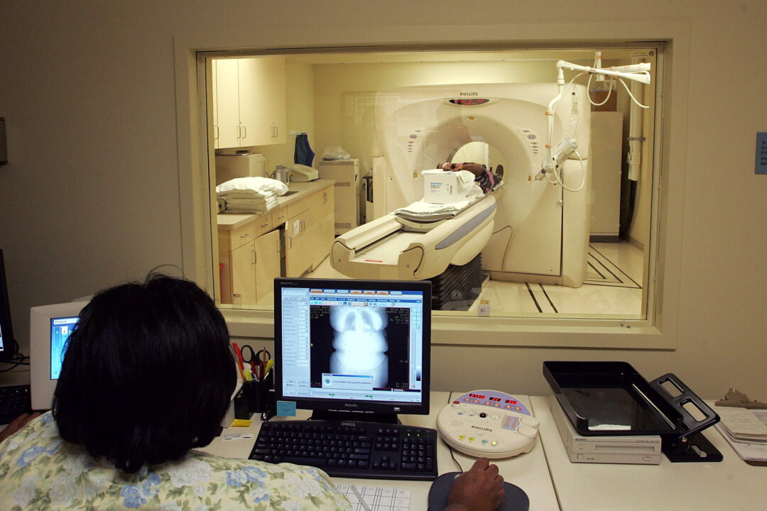 A person looks on as breast cancer patient runs through a CT scan at the UCSF Comprehensive Cancer Center in San Francisco, California, on Aug. 17, 2005. (Justin Sullivan/Getty Images)