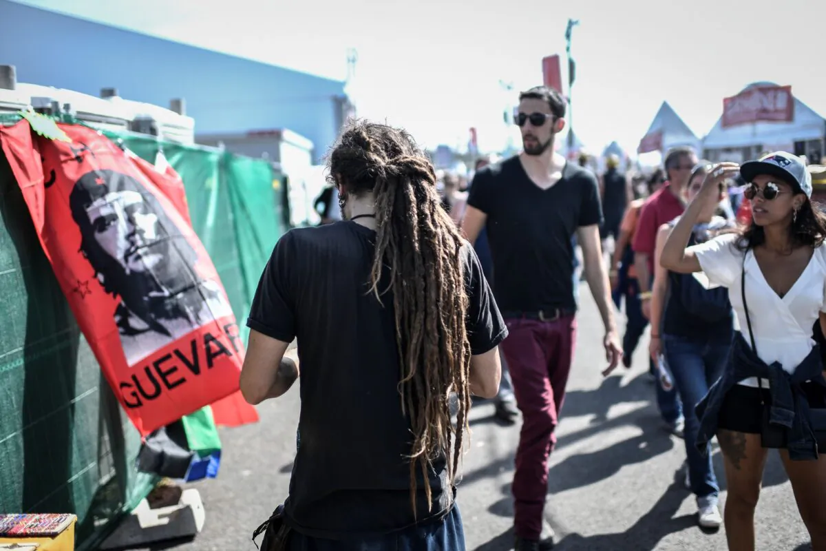 People pass by a flag depicting Argentine-born revolutionary leader Ernesto "Che" Guevara during the 84th edition of the annual "Fete de l'Humanite" music festival in the Paris suburb of La Courneuve on Sept. 14, 2019. (STEPHANE DE SAKUTIN/AFP/Getty Images)