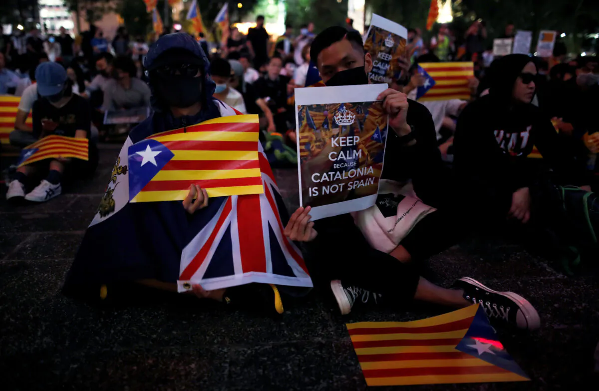 Pro-democracy demonstrators hold Esteladas (Catalan separatist flags), an Union Jack flag and banners as they gather in Hong Kong’s Chater Garden to show their solidarity with the Catalonian independence movement in Spain, in Hong Kong, China, on Oct. 24, 2019. (Ammar Awad/Reuters)