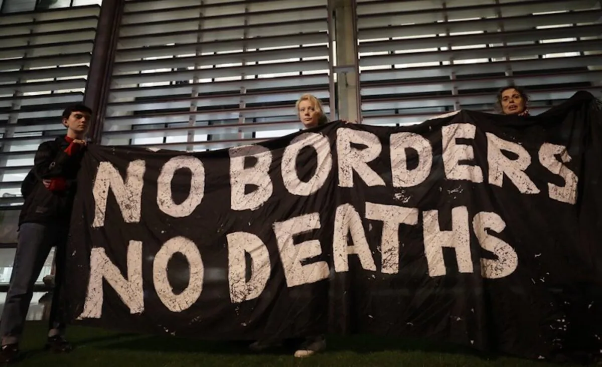 Demonstrators hold a banner during a vigil for the 39 lorry victims, outside the Home Office in London on Oct. 24, 2019. Authorities found 39 people dead in a truck in an industrial park in England on Oct. 23 and arrested the driver on suspicion of murder in one of Britain's worst human-smuggling tragedies. (Kirsty Wigglesworth/AP)