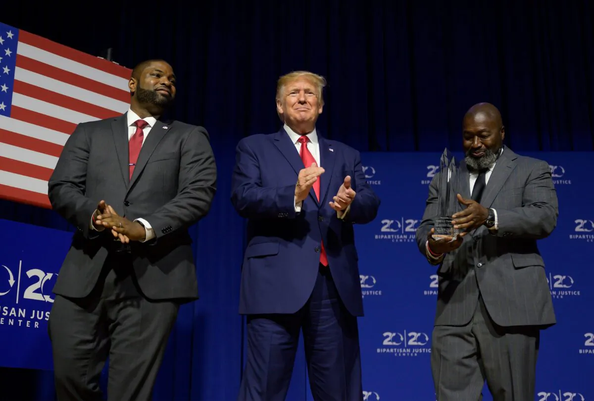 President Donald Trump (C) is awarded the Bipartisan Justice Award by Matthew Charles (R), who was released from federal prison through the First Step Act, prior to delivering remarks at the 2019 Second Step Presidential Justice Forum in Columbia, South Carolina on Oct. 25, 2019. (Jim Watson/AFP via Getty Images)