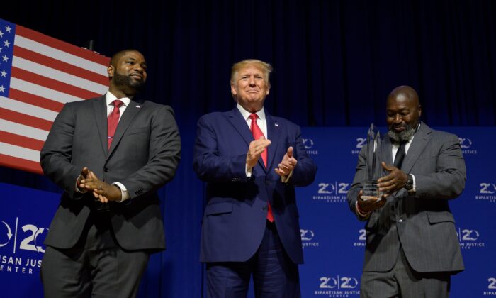 President Donald Trump (C) is awarded the Bipartisan Justice Award by Matthew Charles (R), who was released from federal prison through the First Step Act, prior to delivering remarks at the 2019 Second Step Presidential Justice Forum in Columbia, South Carolina on Oct. 25, 2019. (Jim Watson/AFP via Getty Images)