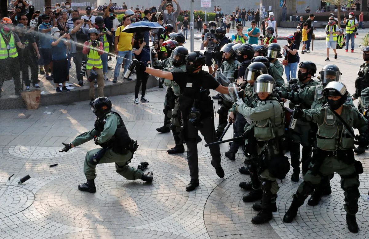 Police officers release pepper spray during a protest in Hong Kong's tourism district of Tsim Sha Tsui, on Oct. 27, 2019. (Umit Bektas/Reuters)