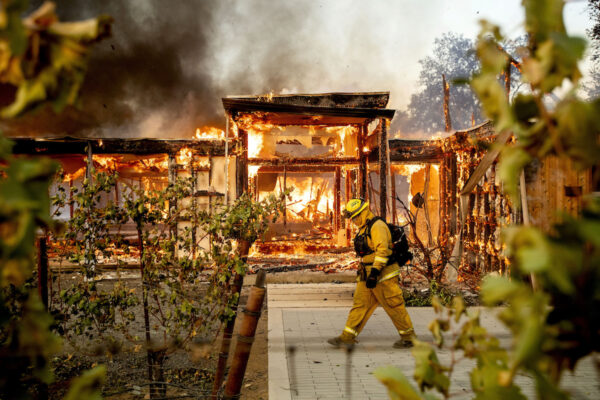 Firefighter Joe Zurilgen passes a burning home