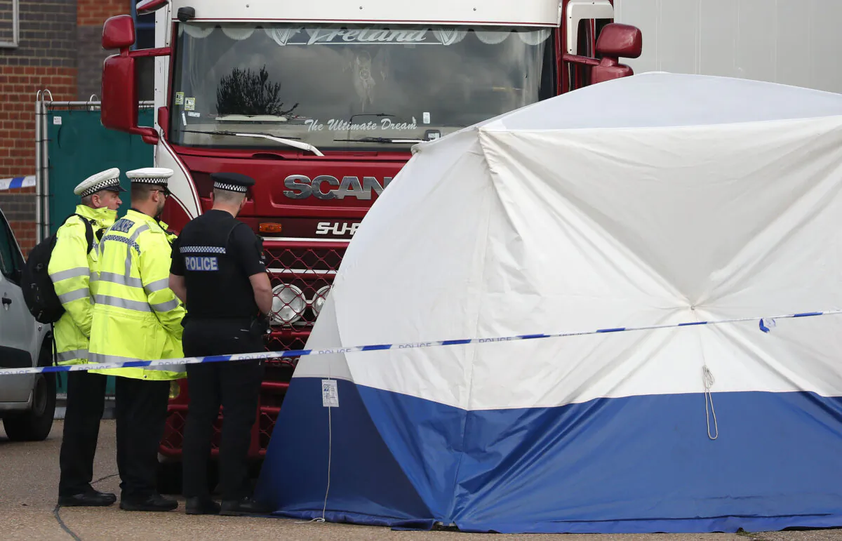 Police officers attend the scene after a truck was found to contain a large number of dead bodies in southeastern England, on Oct. 23, 2019. (AP Photo/Alastair Grant)