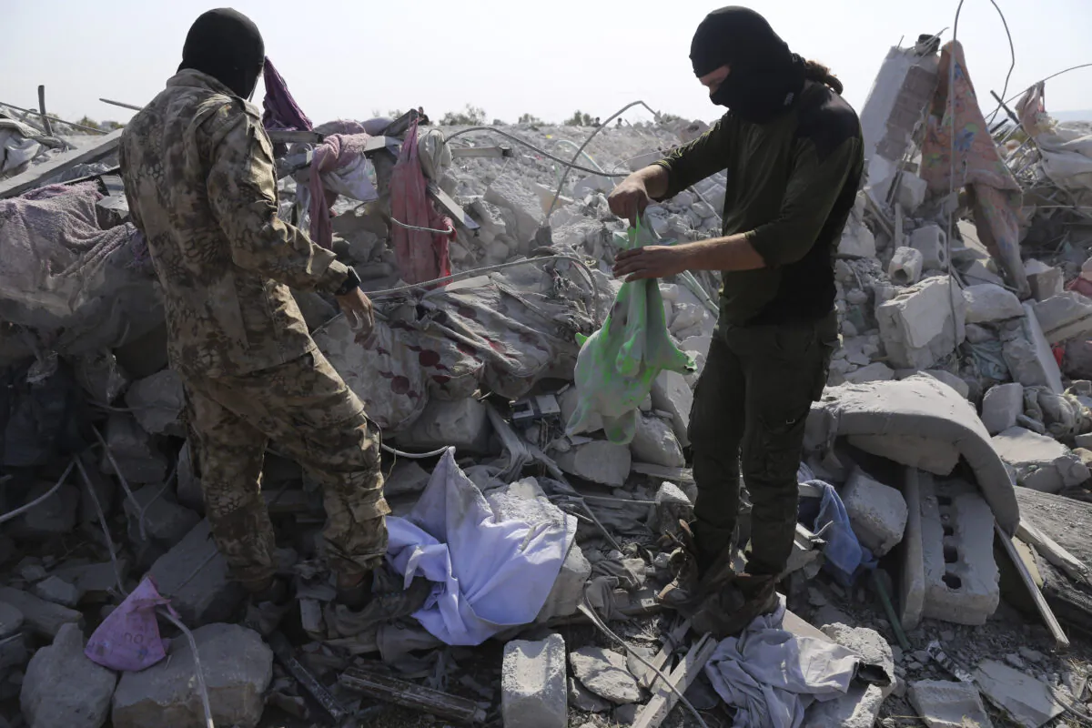 People look at a destroyed houses near the village of Barisha after an operation by the U.S. military which targeted Abu Bakr al-Baghdadi, the shadowy leader of ISIS, in Idlib province, Syria, on Oct. 27, 2019. (Ghaith Alsayed/AP Photo)