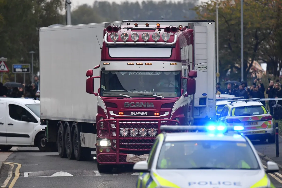 Police officers drive away a lorry (C) in which 39 dead bodies were discovered sparking a murder investigation at Waterglade Industrial Park in Grays, east of London, on Oct. 23, 2019. (Ben Stansall/AFP/Getty Images)