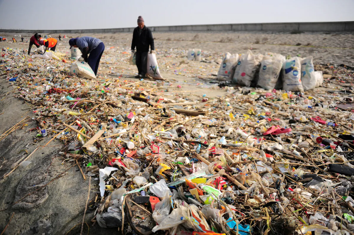 Workers clear garbage at the bank of Yangtze River in Taicang, Jiangsu Province, China on Dec. 23, 2016. (Reuters)