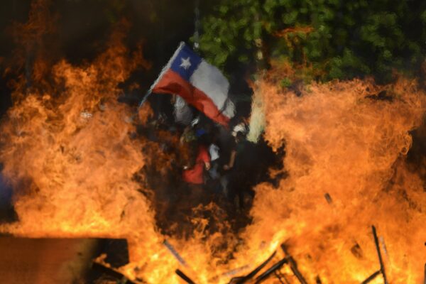 Seen through a burning street barricade