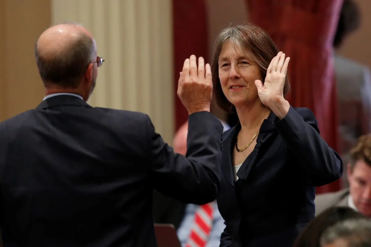 In this file photo, state Sen. Nancy Skinner (D-Berkeley) and state Sen. Steven Glazer (D-Orinda) slap palms in celebration after a measure was approved by the Senate in Sacramento, Calif., on Sept 11, 2019. (Rich Pedroncelli/AP Photo)