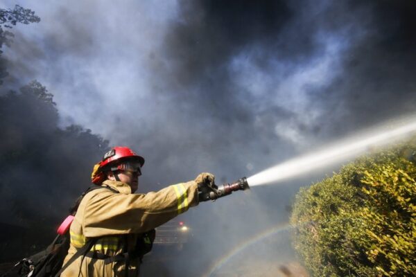 A firefighter battles a wildfire near a ranch in Simi Valley, Calif.