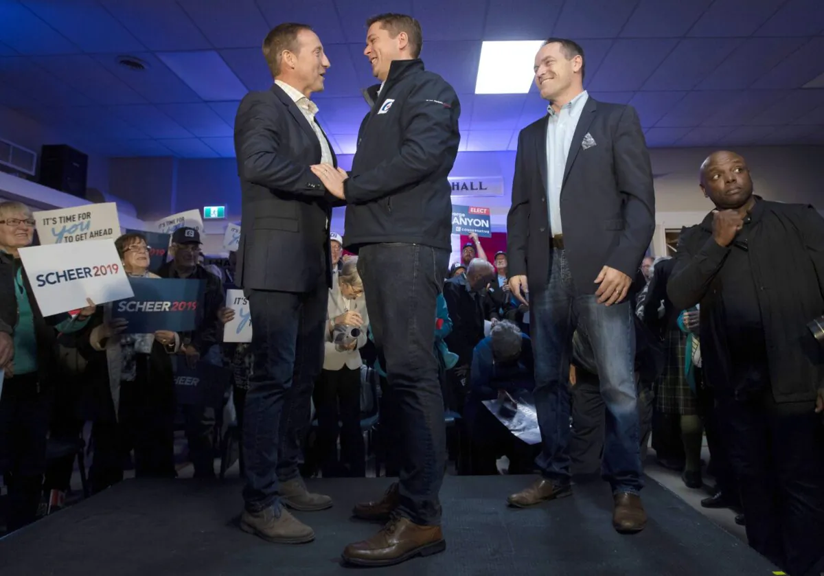 Conservative leader Andrew Scheer shakes hands with Peter MacKay as local Conservative candidate George Canyon looks on during a campaign stop in Little Harbour, N.S., on Oct. 17, 2019. (THE CANADIAN PRESS/Adrian Wyld)