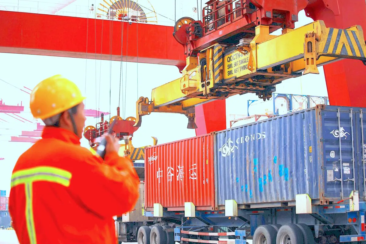 An employee watches over cranes as he talks on his interphone at a port in Qingdao, east China's Shandong Province on Nov. 8, 2018. (STR/AFP/Getty Images)