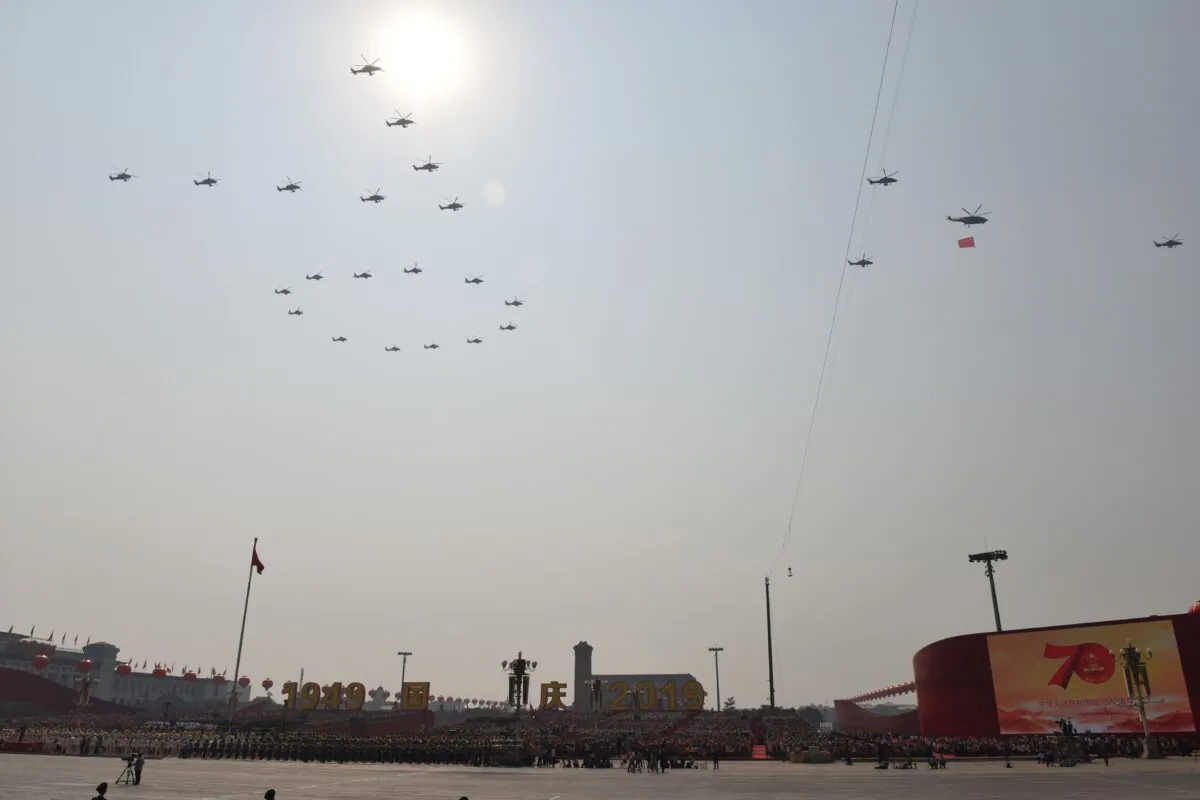 Helicopters fly in formation to create the number 70 during a military parade at Tiananmen Square in Beijing to mark the 70th anniversary of the founding of Chinese Communist regime on Oct. 1, 2019. The three military officers who died in the fatal helicopter crash during a Hong Kong military drill participated in this formation. (Greg Baker/AFP via Getty Images)