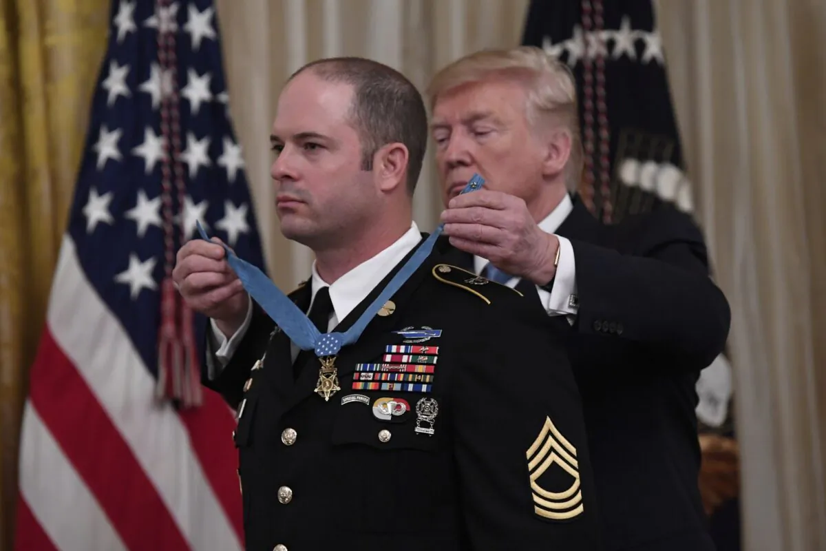 President Donald Trump presents Army Master Sgt. Matthew Williams, left, currently assigned to the 3rd Special Forces Group, with the Medal of Honor during a ceremony in the East Room of the White House in Washington on Oct. 30, 2019. (Susan Walsh/AP Photo)