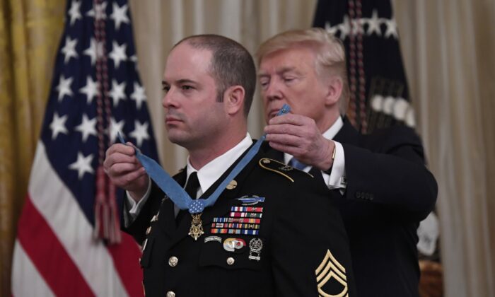 President Donald Trump presents Army Master Sgt. Matthew Williams, left, currently assigned to the 3rd Special Forces Group, with the Medal of Honor during a ceremony in the East Room of the White House in Washington on Oct. 30, 2019. (Susan Walsh/AP Photo)