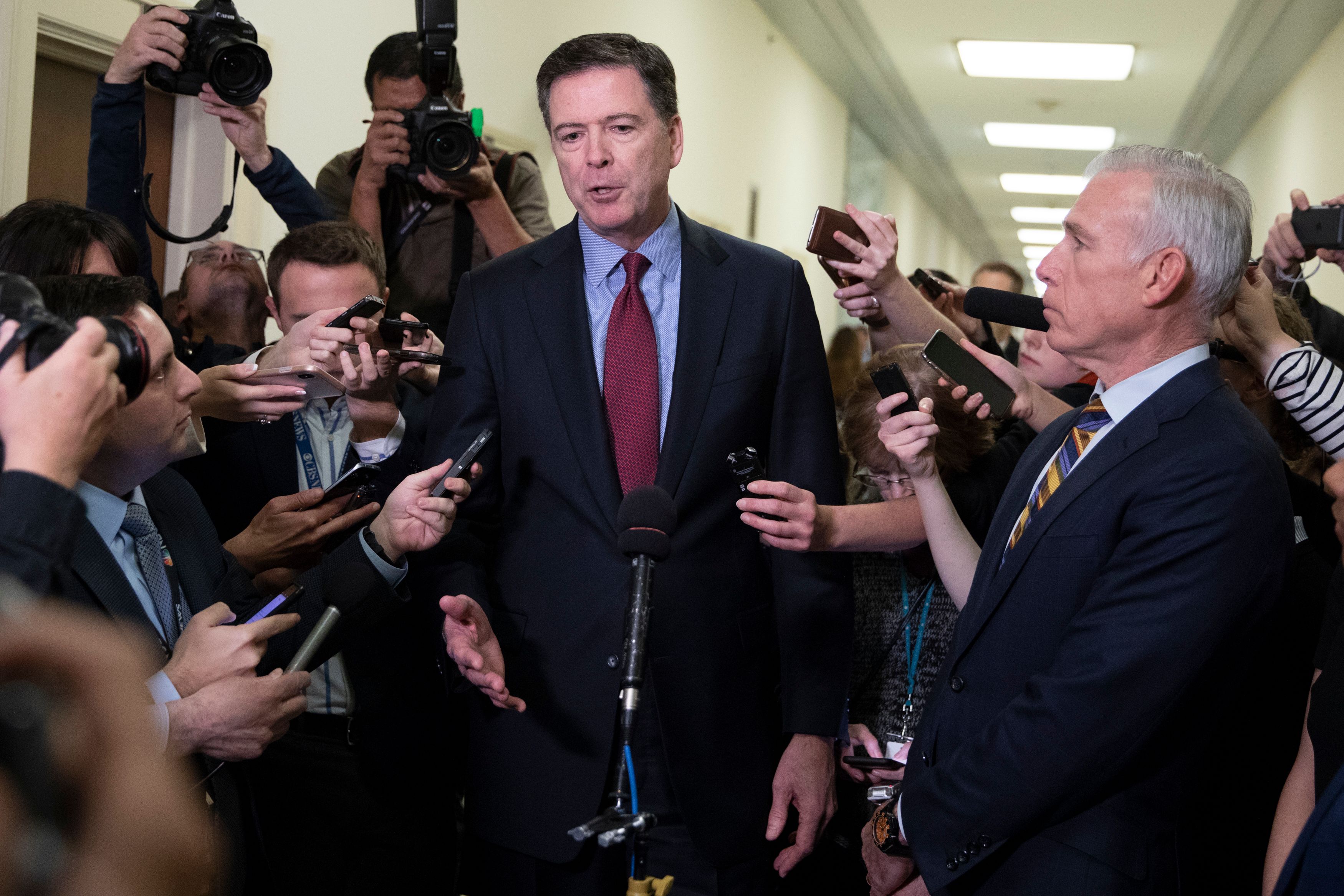Former FBI Director James Comey (C) talks to reporters following a closed House Judiciary Committee meeting to hear his testimony, on Capitol Hill in Washington