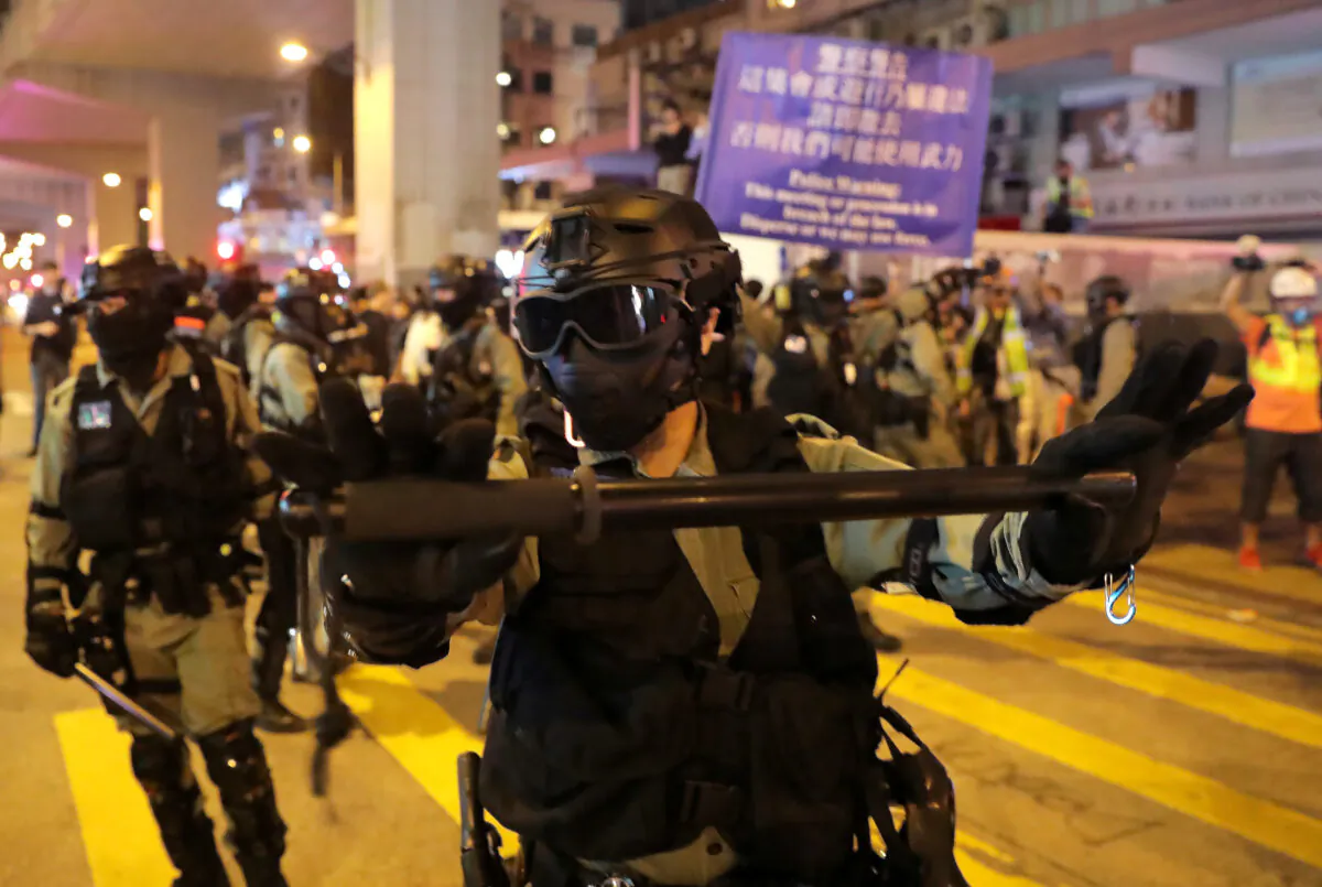 Riot police officers block the street as protesters rally outside Prince Edward MTR station in Hong Kong, China, on Nov. 30, 2019. (Marko Djurica/Reuters)