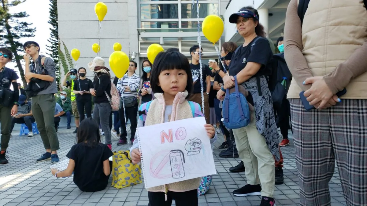 A girl holds a sketch showing no to tear gas at a rally at Edinburgh Place in Hong Kong, on Dec. 1, 2019. (Bill Cox/The Epoch Times)