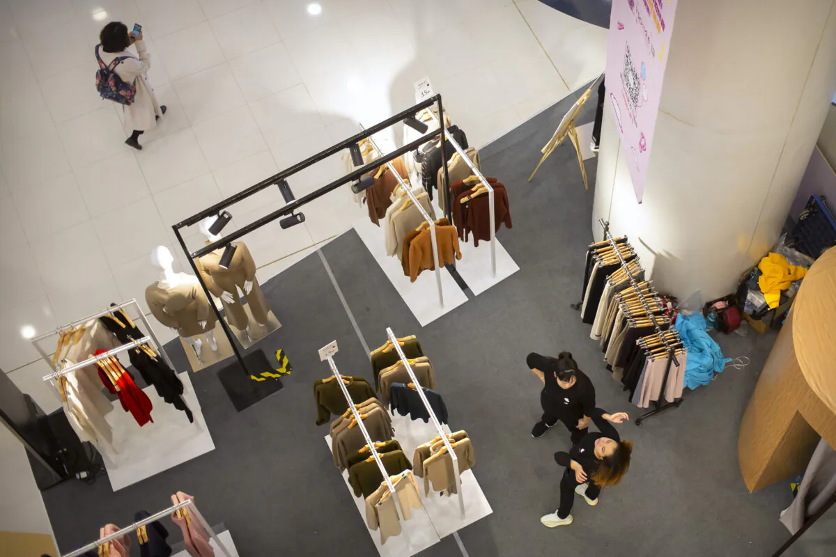 Employees wait for customers at a discount clothing retailer in a shopping mall in Beijing on Oct. 31, 2019. (Mark Schiefelbein/AP Photo)