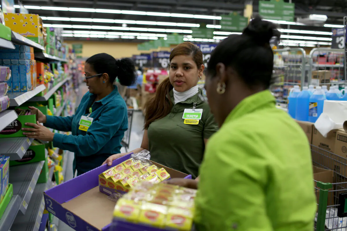 Walmart employee Yanetsi Grave (C) and her fellow employees stock the shelves at a Walmart store on Feb. 19, 2015 in Miami, Fla. (Joe Raedle/Getty Images)