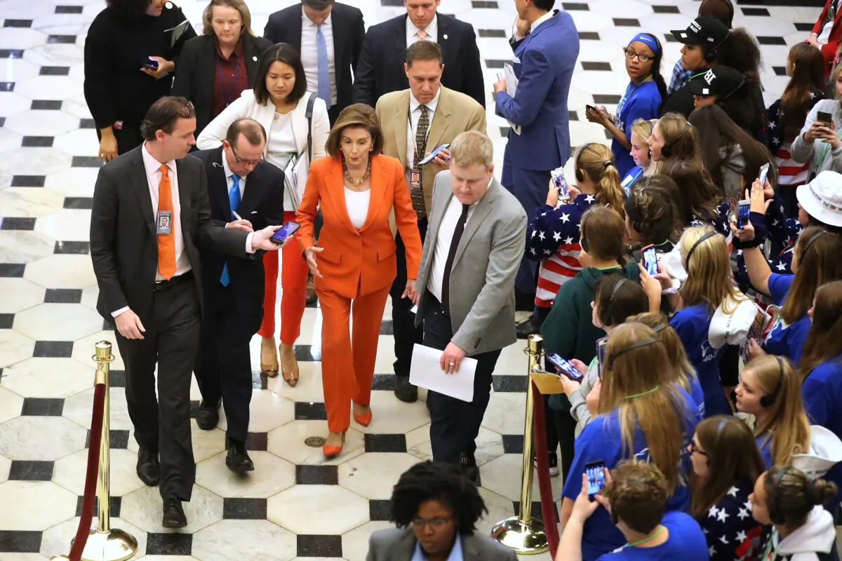 House Speaker Nancy Pelosi (D-Calif.) is surrounded by staff and journalists as she leaves the floor after the close of a vote by the U.S. House of Representatives on a resolution formalizing the impeachment inquiry against Republican President Donald Trump in Washington on Oct. 31, 2019. (Chip Somodevilla/Getty Images)