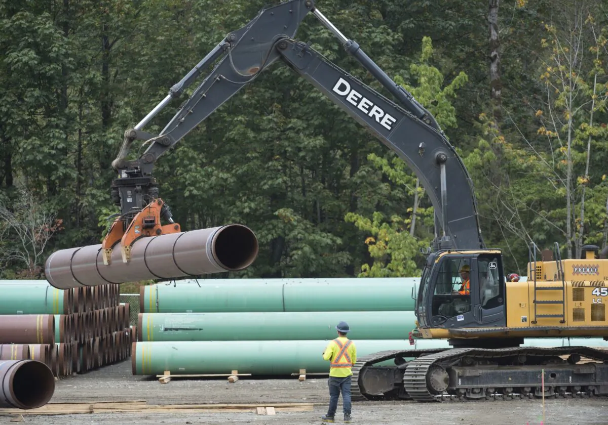 Workers stack pipeline pipes at a Trans Mountain facility near Hope, B.C., on Aug. 22, 2019. (THE CANADIAN PRESS/Jonathan Hayward)