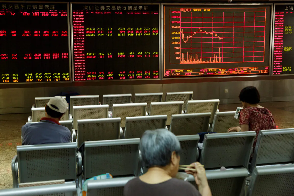 People sit in front of a board showing market information at a securities brokerage house in Beijing, China on Aug. 5, 2019. (Thomas Peter/Reuters)