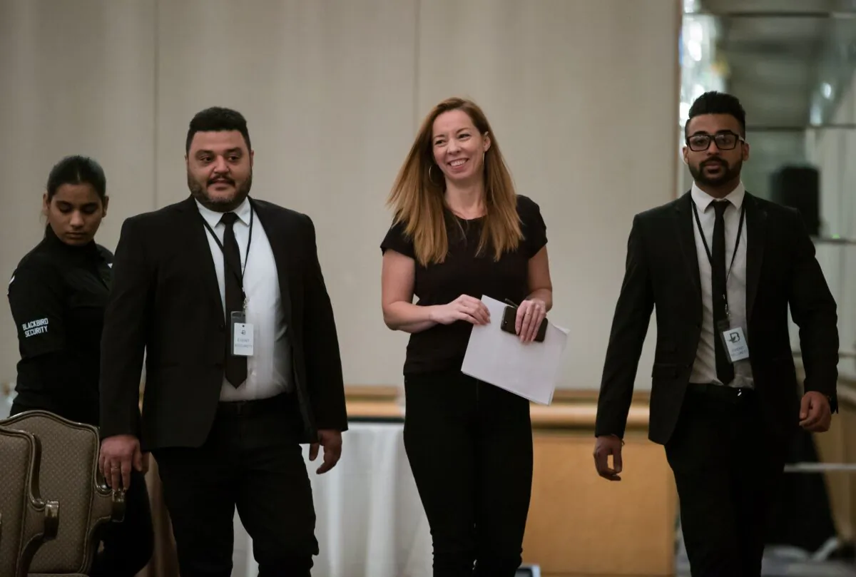 Writer Meghan Murphy is flanked by security before speaking at a panel discussion on gender identity in Vancouver on Nov. 2, 2019. (THE CANADIAN PRESS/Darryl Dyck)