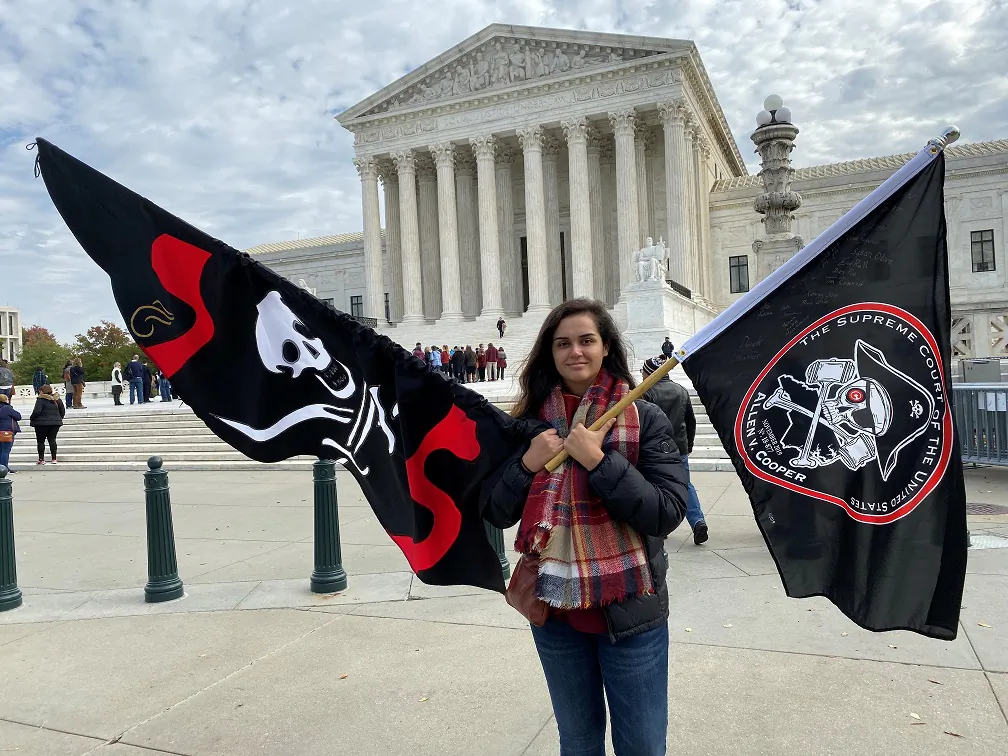 Christina Burnham holds pirate-themed flags in front of the Supreme Court in support of her uncle, Frederick Allen, a filmmaker whose appeal in a copyright lawsuit over the use of his footage of Blackbeard’s shipwreck is being heard by the justices, in Washington Nov. 5, 2019. (REUTERS/Andrew Chung)