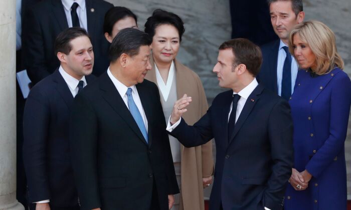 French President Emmanuel Macron and his wife Brigitte Macron (R) speak with Chinese leader Xi Jinping and his wife Peng Liyuan (C) following a meeting at the Elysee Palace in Paris on March 26, 2019. (THIBAULT CAMUS/AFP via Getty Images)