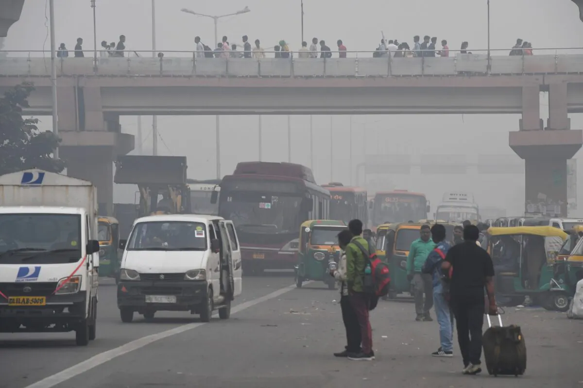 People make their way on a street in smoggy conditions in New Delhi on Nov. 4, 2019. (Prakash Singh/AFP via Getty Images)