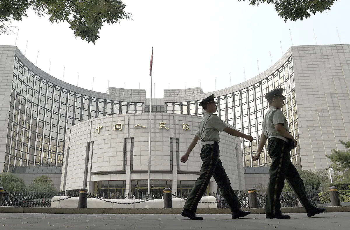 Paramilitary policemen patrol in front of the People's Bank of China, the central bank of China, in Beijing on July 8, 2015. (Greg Baker/AFP/Getty Images)