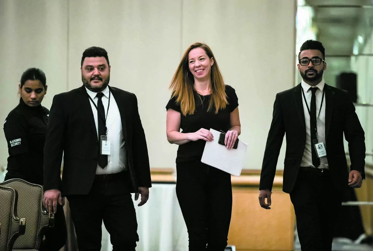 Writer Meghan Murphy walks with security before speaking during a panel discussion on gender identity in Vancouver on Nov. 2, 2019. (The Canadian Press/Darryl Dyck)