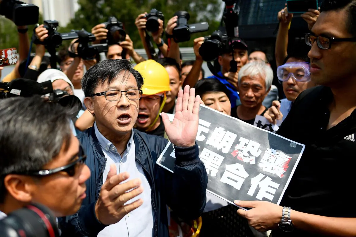 Pro-Beijing Hong Kong lawmaker Junius Ho (centre L) and pro-democracy lawmakers argue before a demonstration of Hong Kong Police's new water cannon equipped vehicle at the Police Tactical Unit compound in Hong Kong on August 12, 2019. (MANAN VATSYAYANA/AFP via Getty Images)