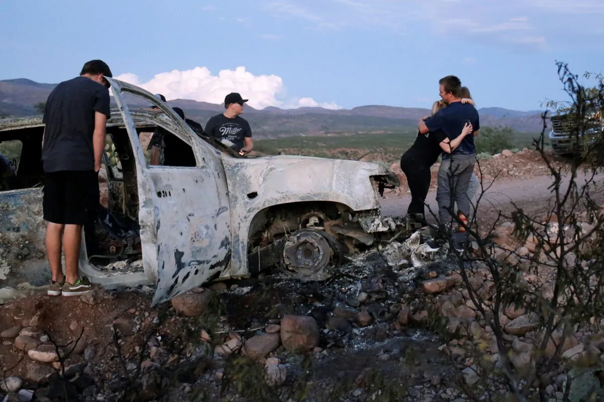 Relatives of slain members of Mexican-American families belonging to Mormon communities observe the burnt wreckage of a vehicle where some of their relatives died, in Bavispe, Sonora state, Mexico, on Nov. 5, 2019. (Jose Luis Gonzalez/Reuters)