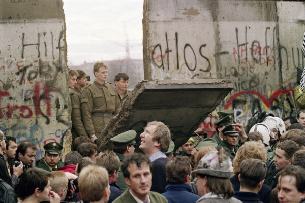 West Berliners crowd in front of the Berlin Wall early 11 November 1989 as they watch East German border guards demolishing a section of the wall in order to open a new crossing point between East and West Berlin, near the Potsdamer Square. ( Gerard Malie/AFP via Getty Images)