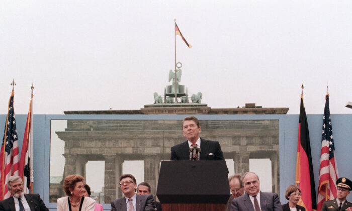 U.S. President Ronald Reagan, commemorating the 750th anniversary of Berlin, addresses the people of West Berlin at the base of the Brandenburg Gate, near the Berlin wall, on June 12, 1987. Reagan famously said, “Mr. Gorbachev, tear down this wall.” (MIKE SARGENT/AFP via Getty Images)