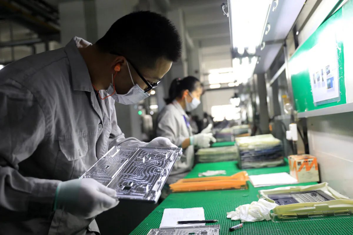 Workers check laptop parts inside a factory in Lu'an City, Anhui Province, China, on November 19, 2018. (STR/AFP via Getty Images)