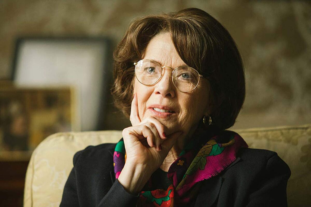 woman with short hair, glasses, and scarf