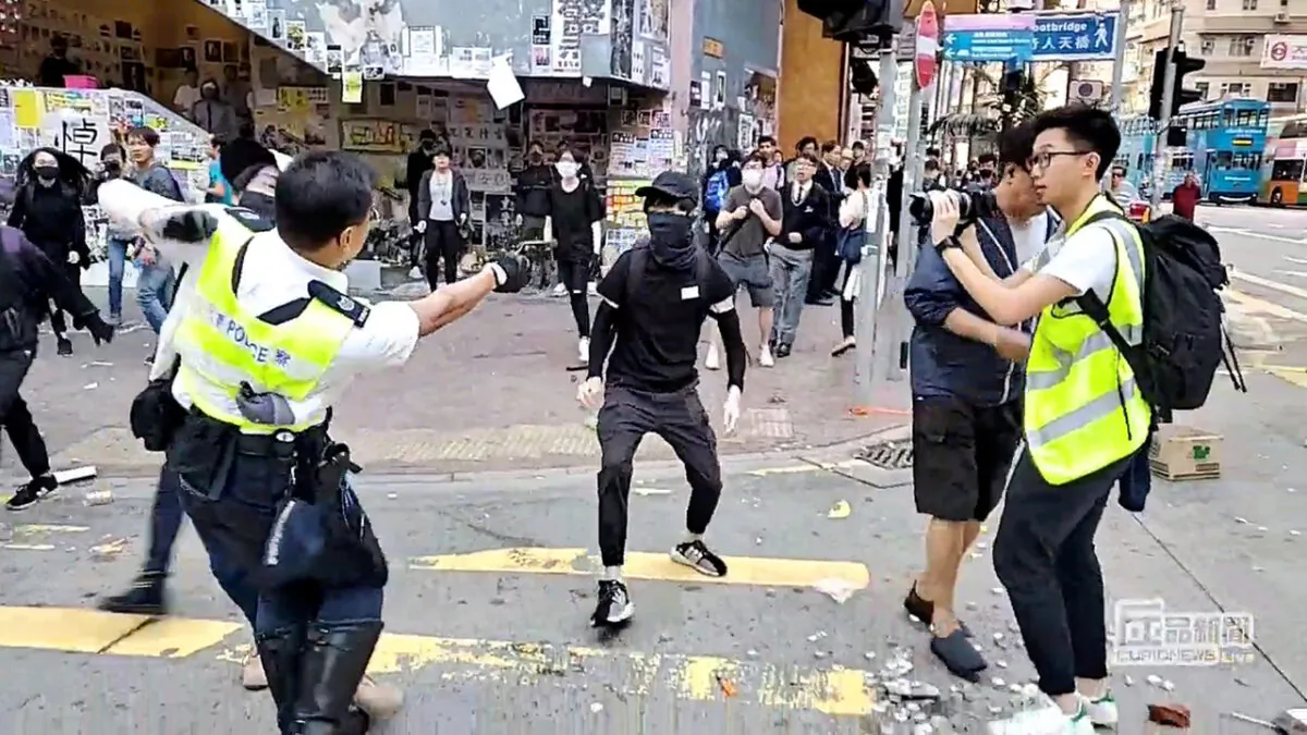 A still image from a social media video shows a police officer aiming his gun at a protester in Sai Wan Ho, Hong Kong, China, on Nov. 11, 2019. (Cupid Producer via Reuters)